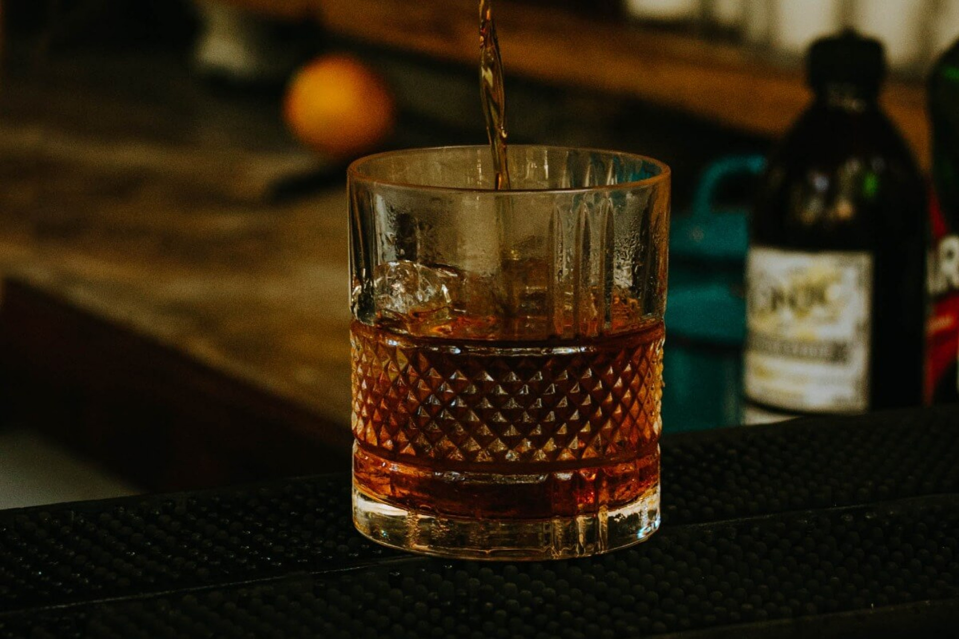 Cognac som hälls upp i ett fint cognacsglas placerad på en träbar